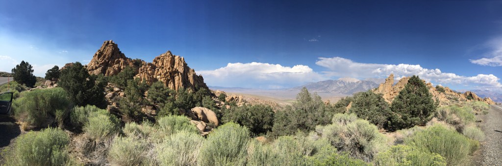 The photo shows a rock formation in the Nevada Desert with a mountain in the background.